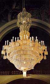 The chandelier decorated with cut glass trimmings. It was hung at the Franciscan Church of Hejnice in Bohemia in 1853 as the gift of Hejnice-born Josef Riedel. The silver-plated frame has 54 arms with candles.